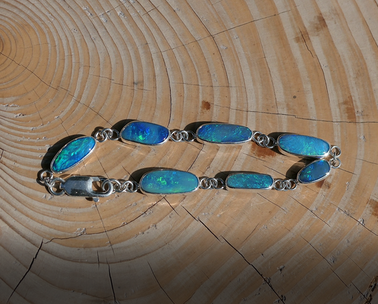 Silver opal bracelet with  Coober Pedy doublet opals.  Bright opals with greens, blues and purples. Bracelet is 200mm long, with a heavy duty crocodile catch.