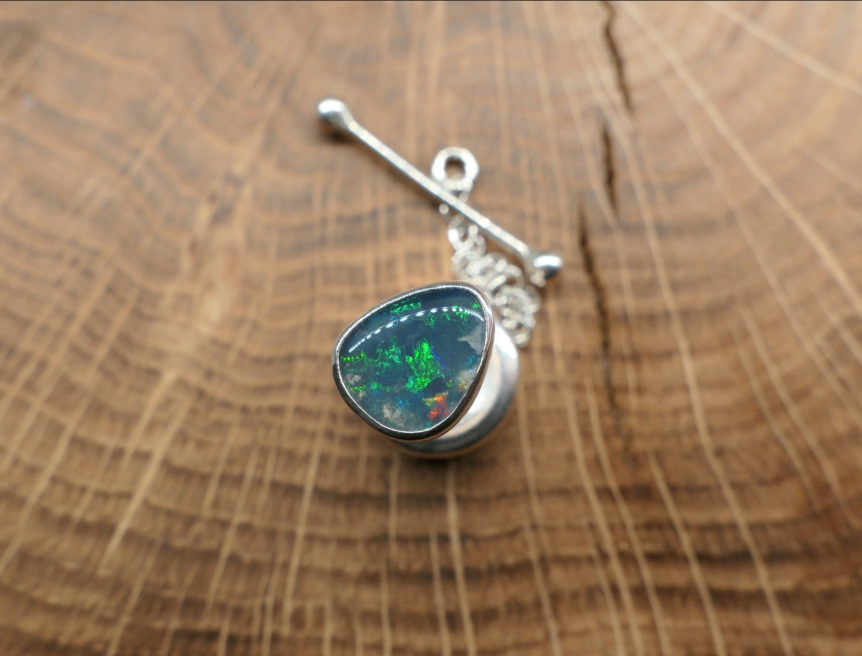 Silver tie tack with a Lightning Ridge doublet.