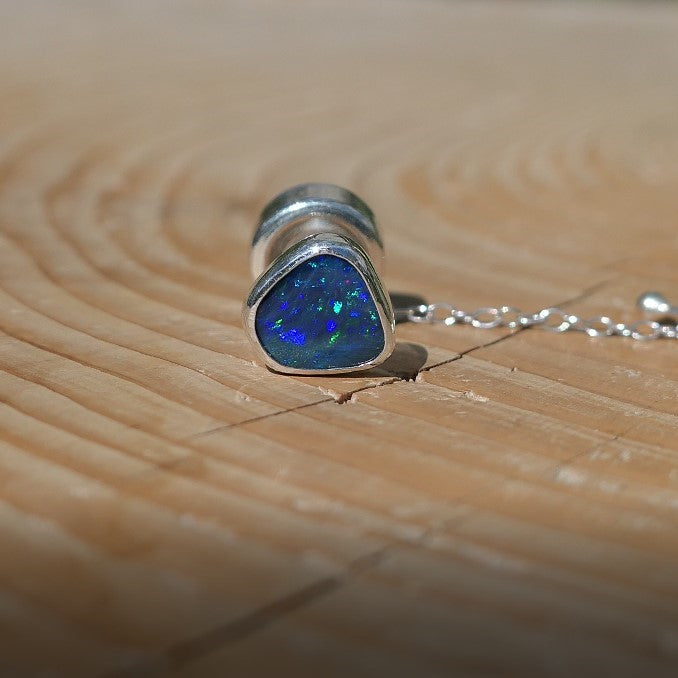 Silver tie tack with a bright Andamooka doublet opal.