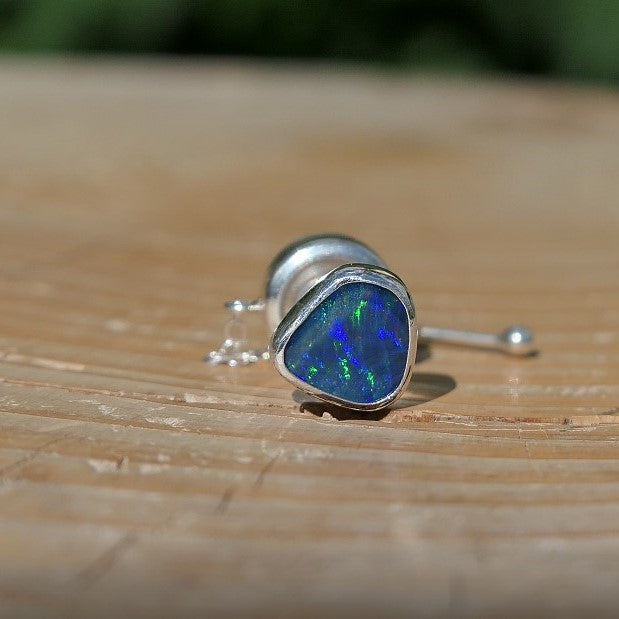 Silver tie tack with a bright Andamooka doublet opal.