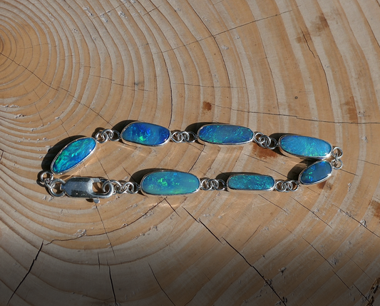 Silver opal bracelet with  Coober Pedy doublet opals.  Bright opals with greens, blues and purples. Bracelet is 200mm long, with a heavy duty crocodile catch. 