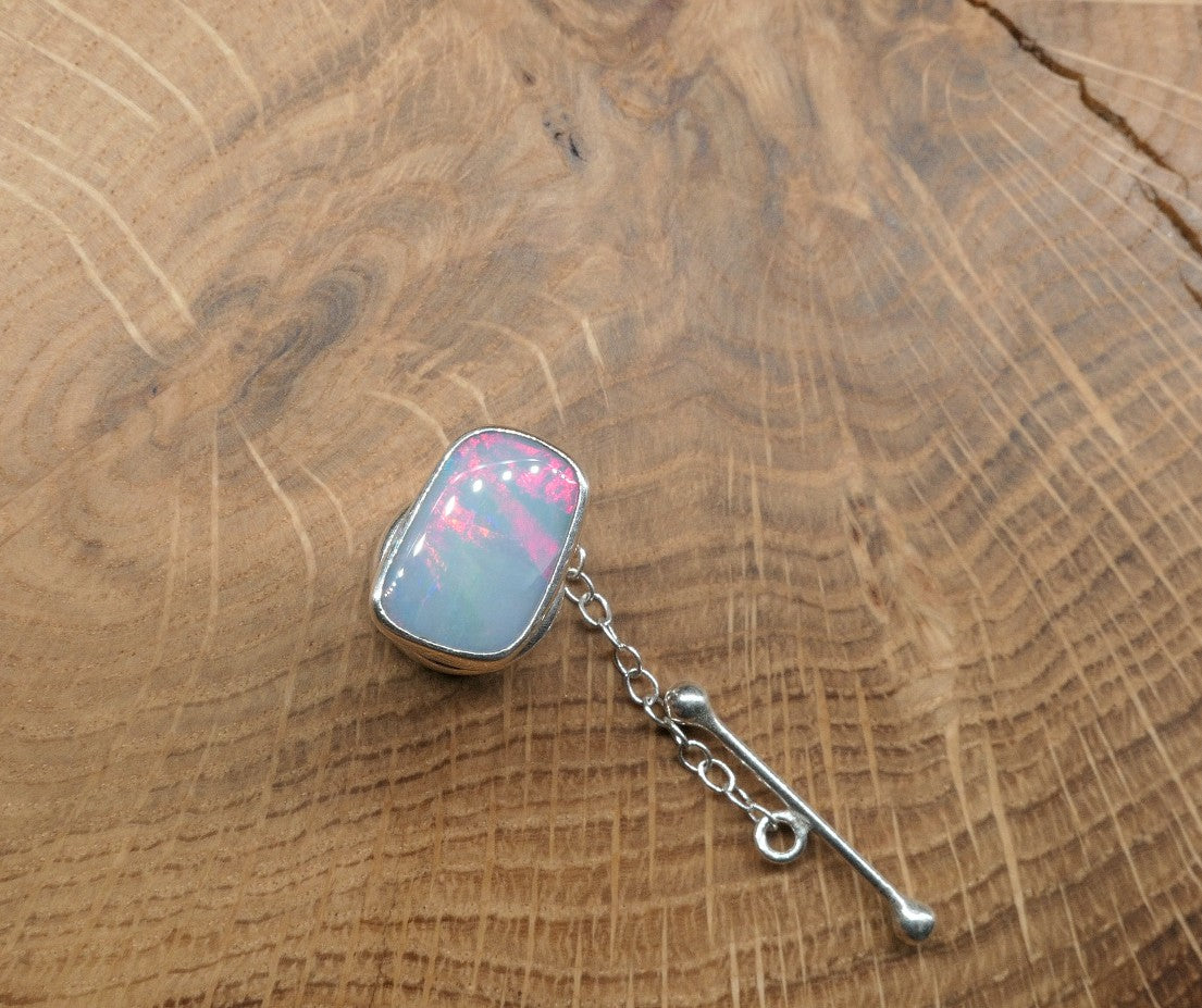 Silver tie tack with a ribbon pattern shell doublet