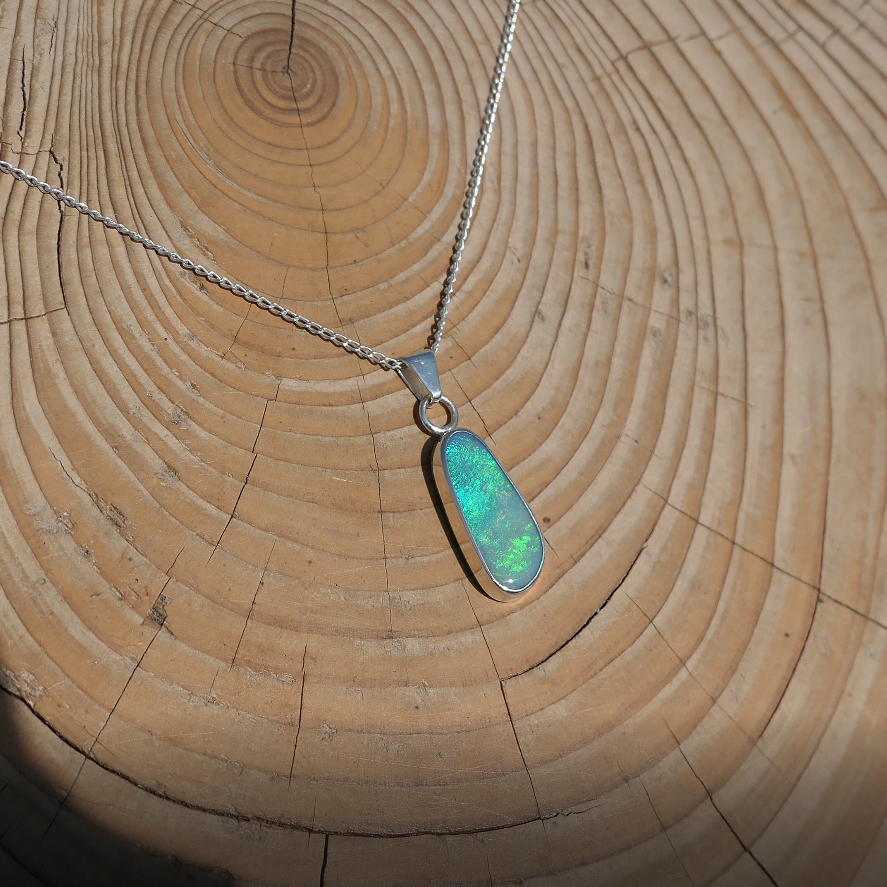 Silver pendant with bright green Coober Pedy opal.