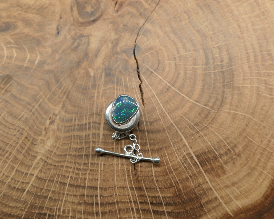 Silver tie tack with a Lightning Ridge doublet.