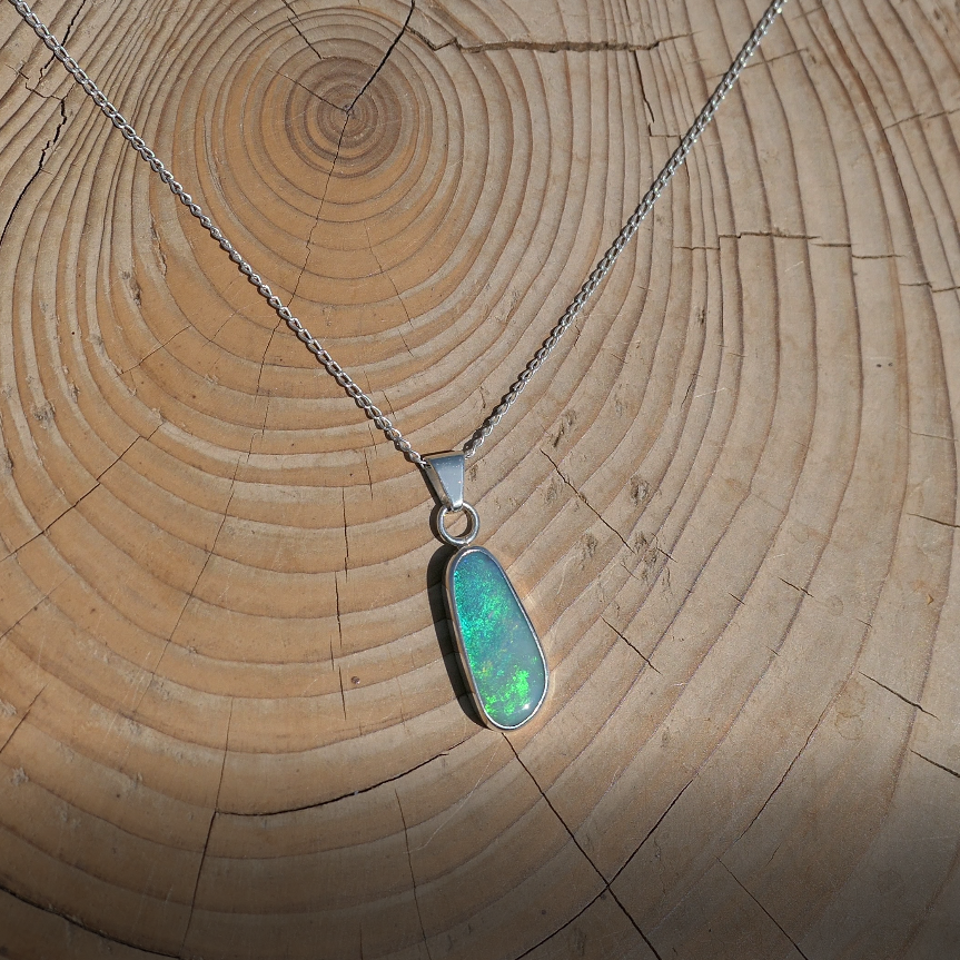 Silver pendant with bright green Coober Pedy opal.