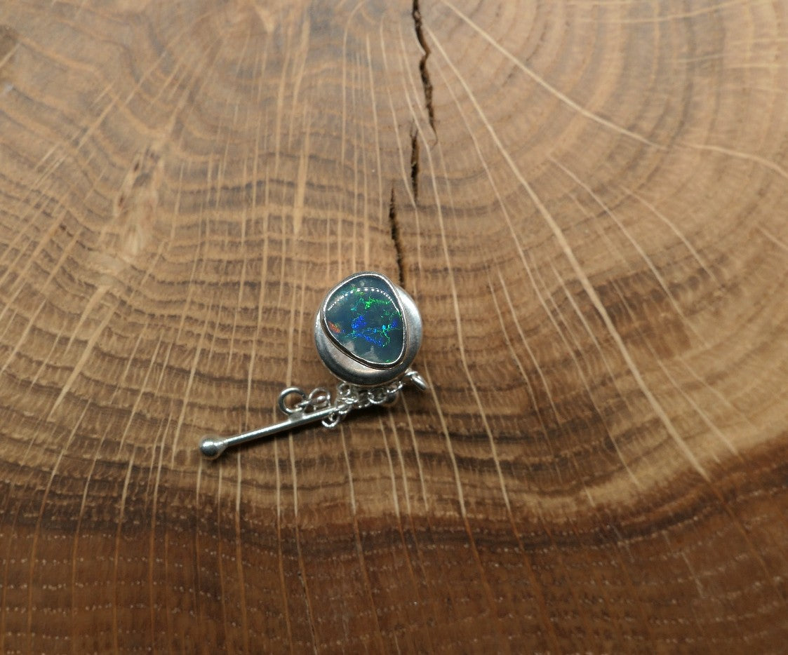 Silver tie tack with a Lightning Ridge doublet.