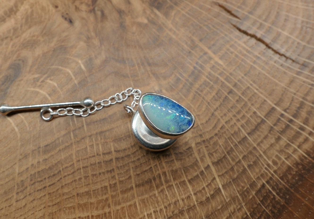 Silver tie tack with an opalised shell doublet