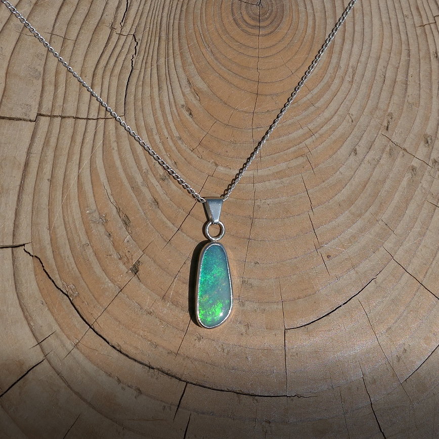 Silver pendant with bright green Coober Pedy opal.