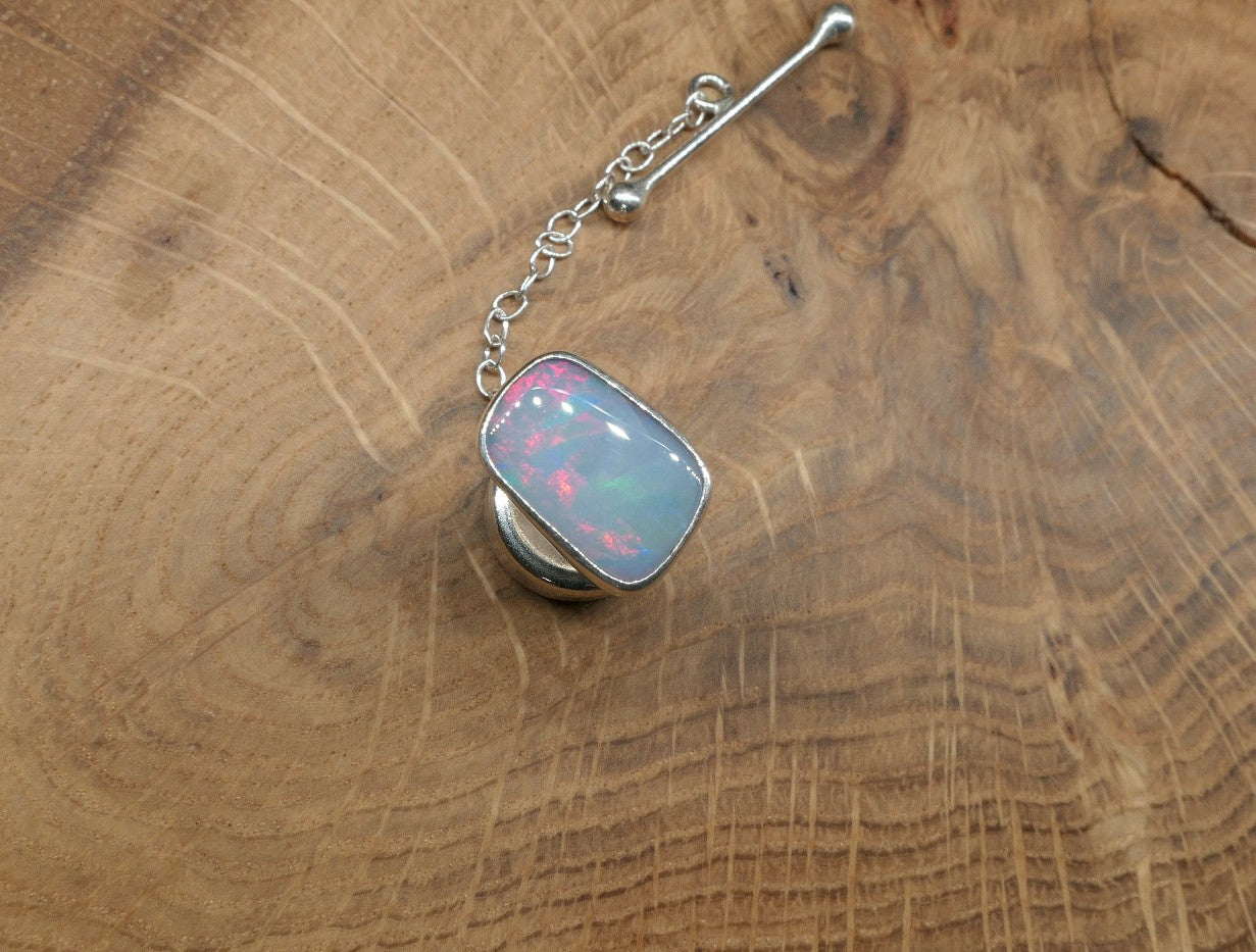 Silver tie tack with a ribbon pattern shell doublet