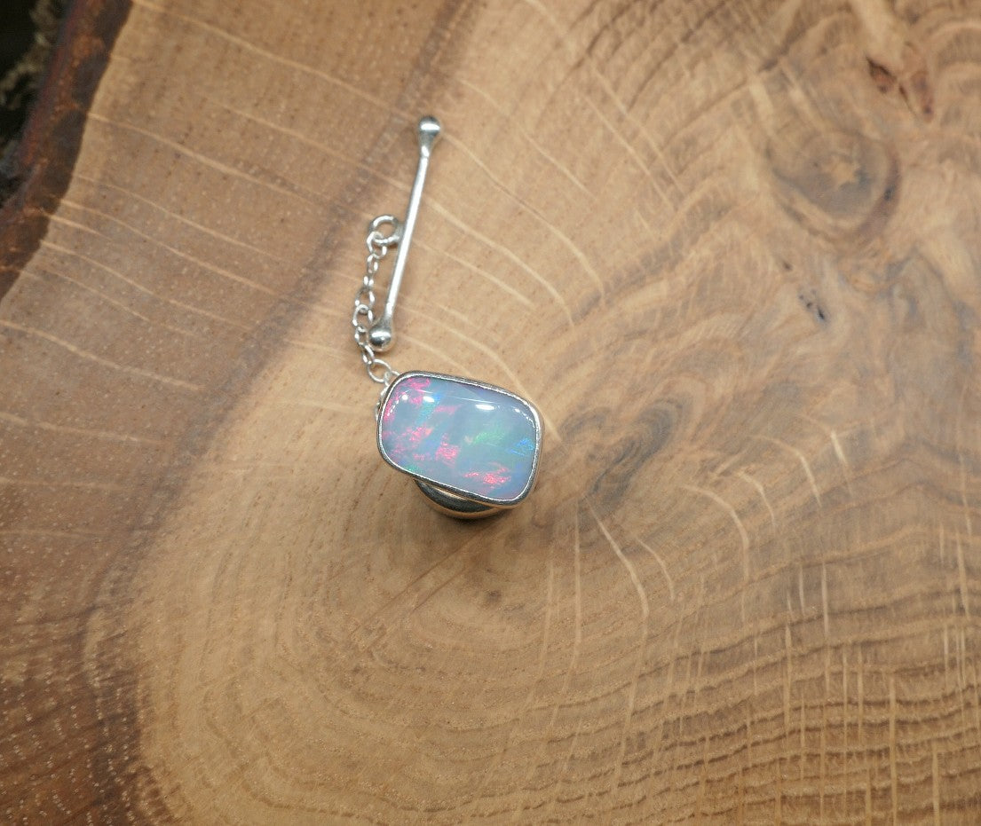 Silver tie tack with a ribbon pattern shell doublet