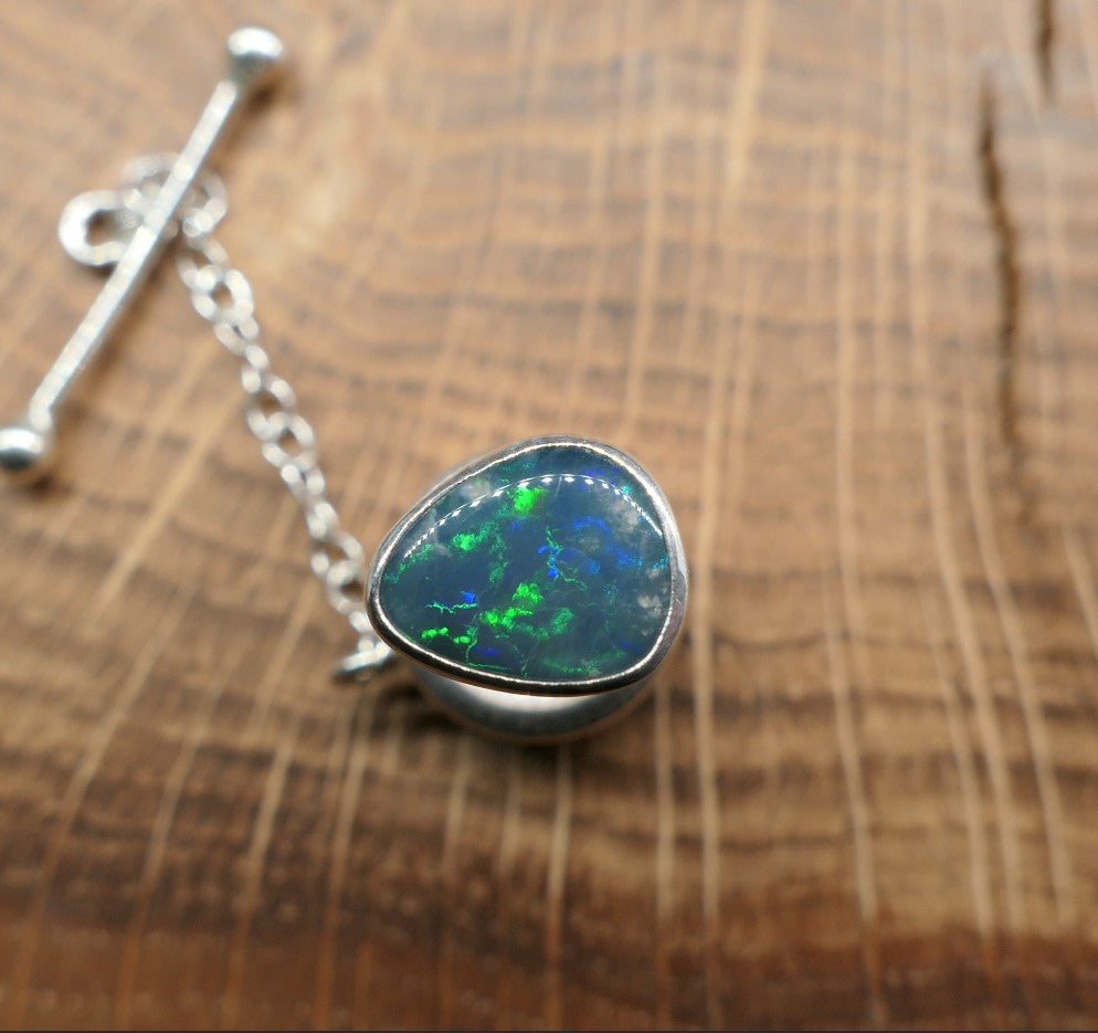 Silver tie tack with a Lightning Ridge doublet.