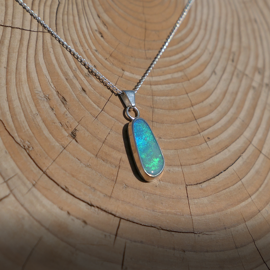 Silver pendant with bright green Coober Pedy opal.