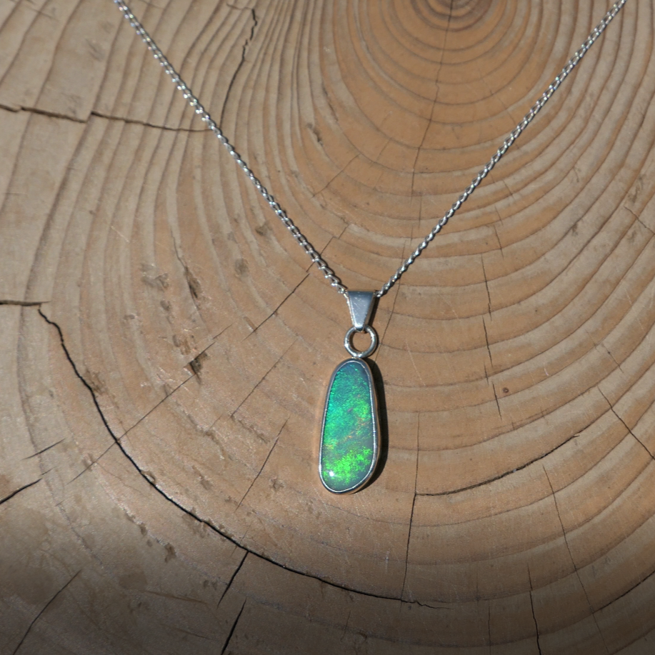 Silver pendant with bright green Coober Pedy opal.