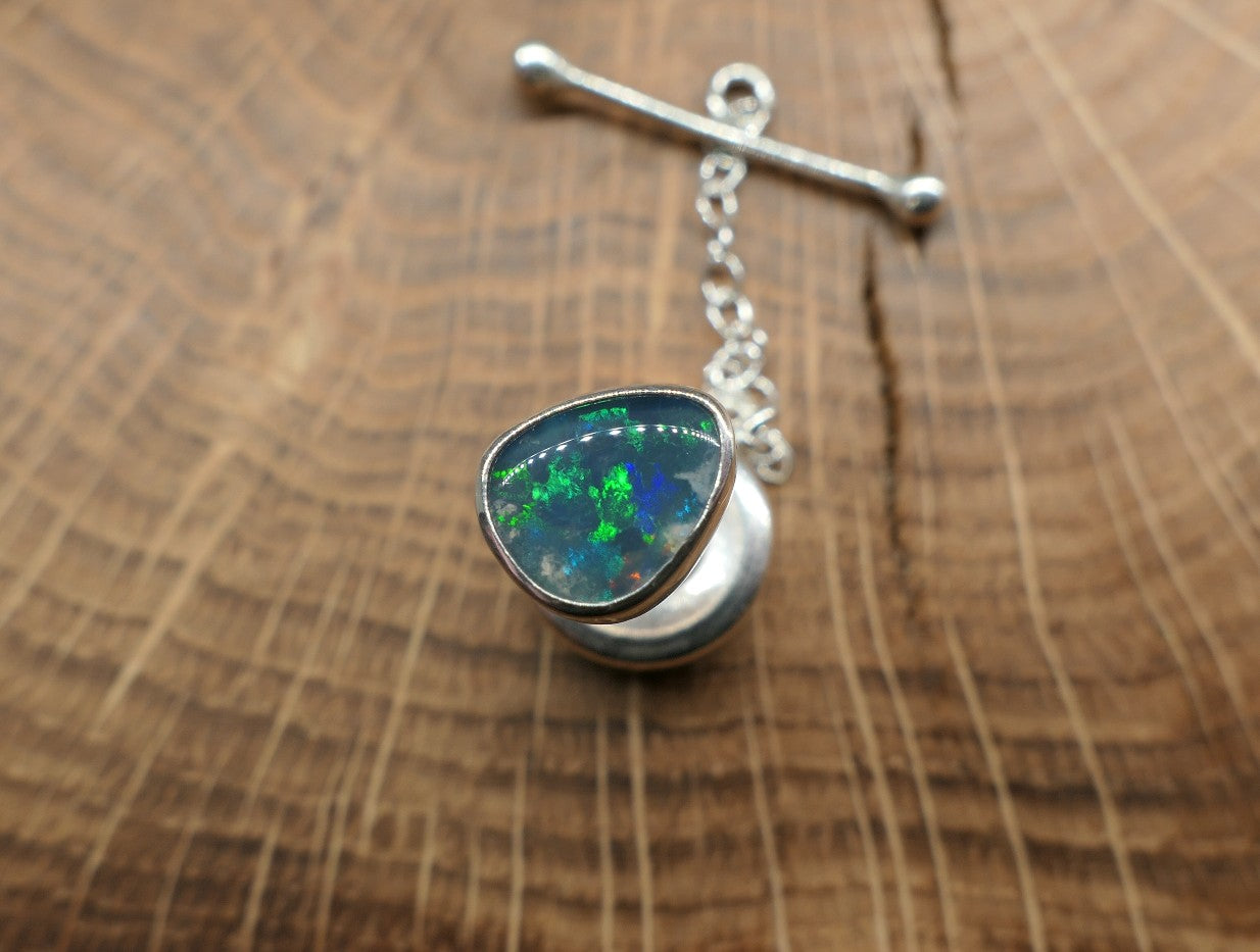 Silver tie tack with a Lightning Ridge doublet.