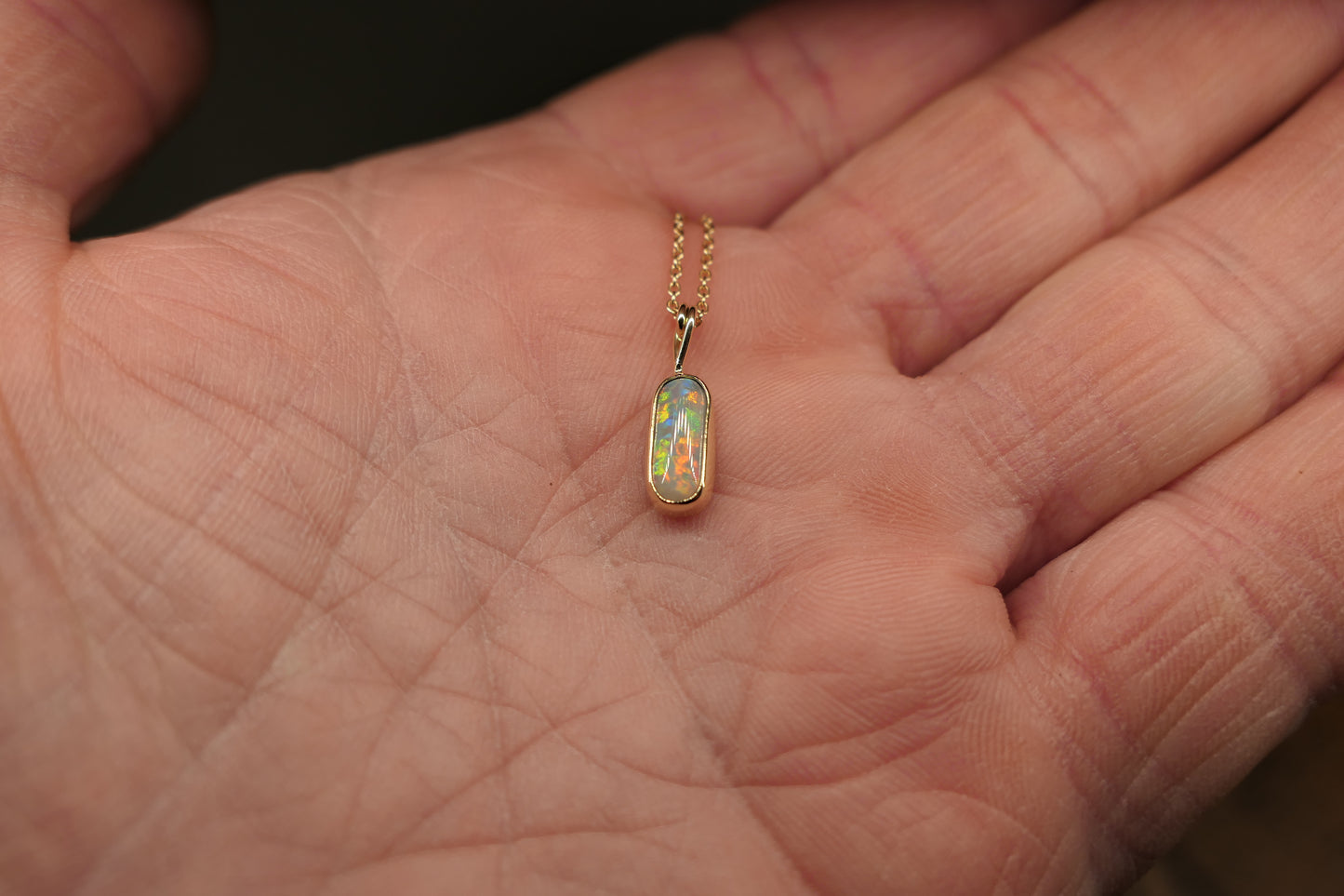 18k gold opal pendant with a Lightning Ridge black opal