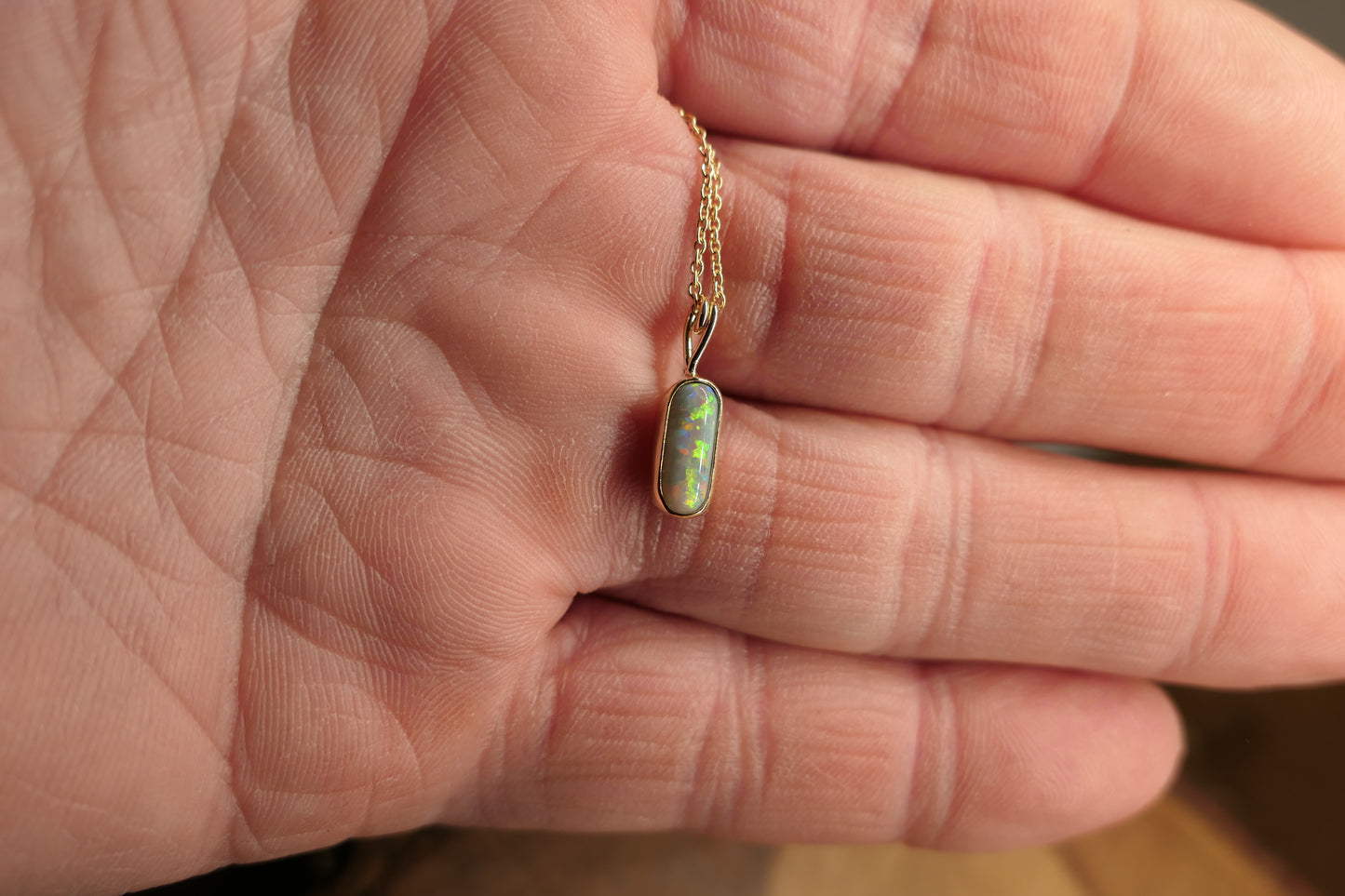 18k gold opal pendant with a Lightning Ridge black opal